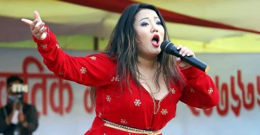 Singer Jyoti Magar performing live in stage wearing red dress